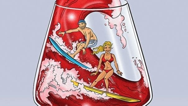 Two people surfing waves inside a wine glass filled with red liquid.