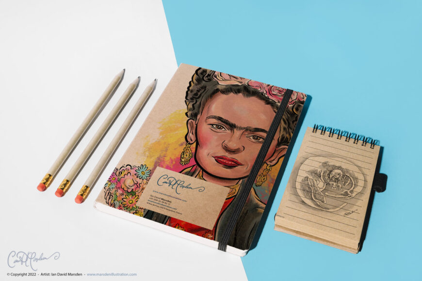 Photo of an illustrated Frida Kahlo notebook alongside a small spiral sketchpad showing a cartoon Loch Ness monster relaxing in a lounge chair.