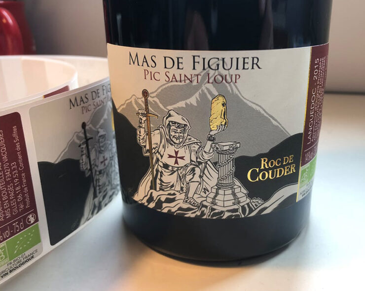 Roc de Couder wine bottle with custom label and strip of bottling labels.