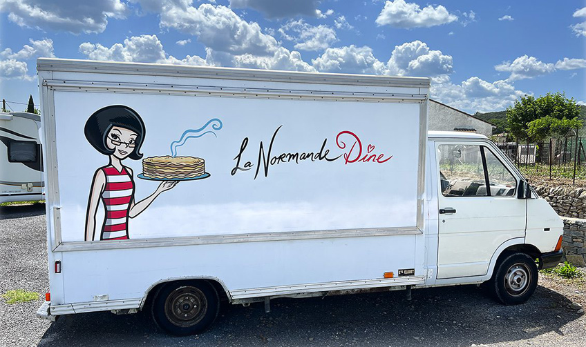 Food truck blanc “La Normande Dîne” avec logo illustré appliqué sur la carrosserie, en région de Montpellier.
