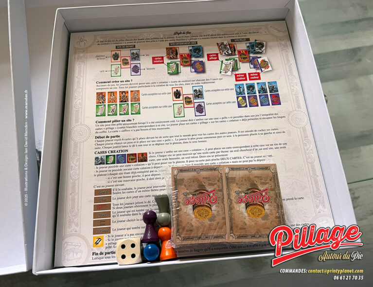 Règles imprimées de Pillage autour du Pic avec schémas, cartes, pictogrammes, pions et éléments de jeu dans la boîte.