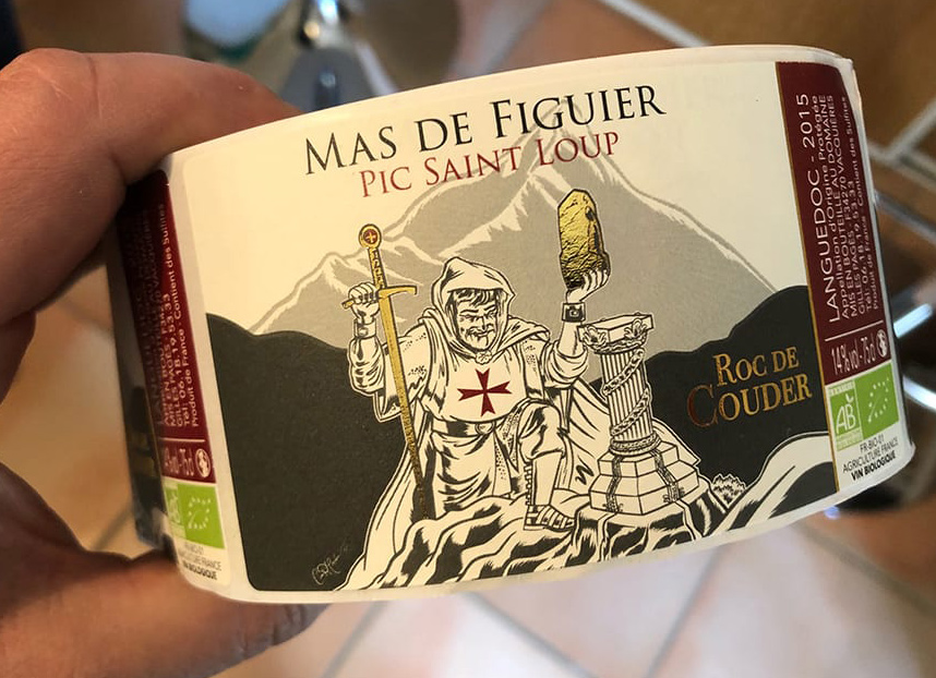 Bande d’étiquettes Roc de Couder imprimées, tenue à la main, avec l’illustration centrale et les finitions dorées visibles.