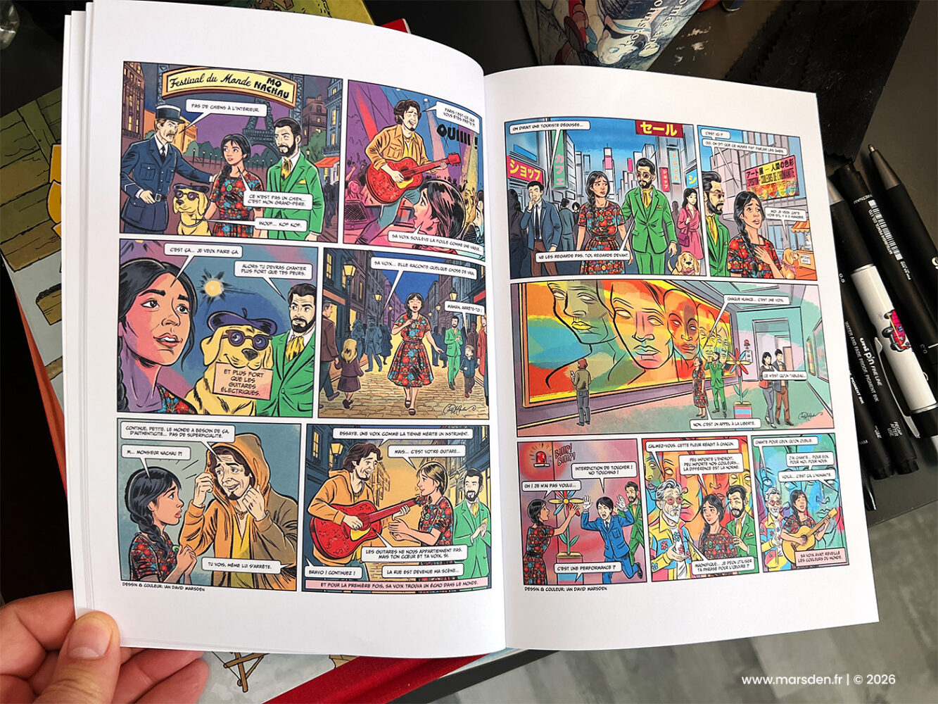 Printed comic-book spread from Samara showing festival, travel and city scenes, illustrated and colored by Ian David Marsden.