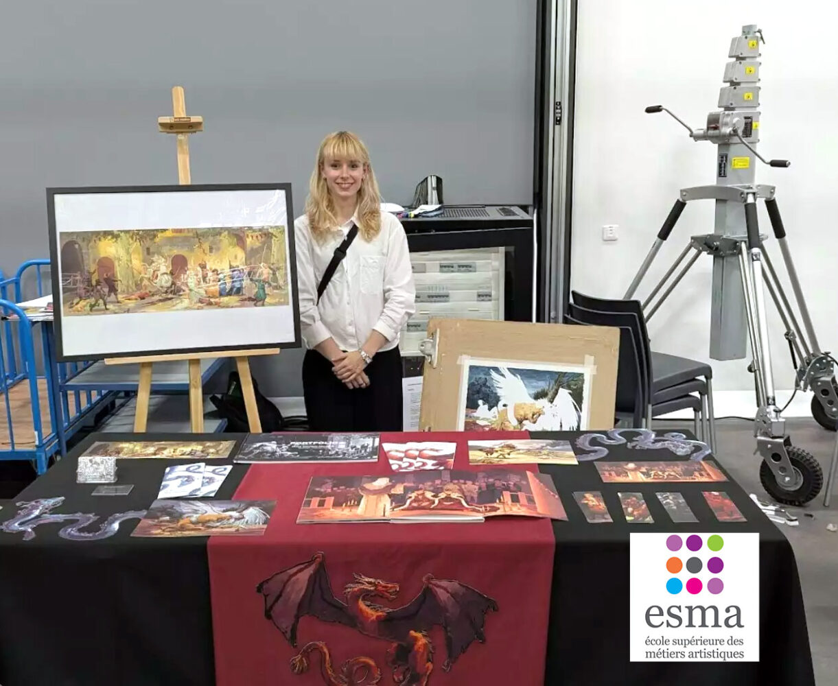 Final-year ESMA Illustration Concept Art student standing beside an illustrated edition project display in Montpellier.