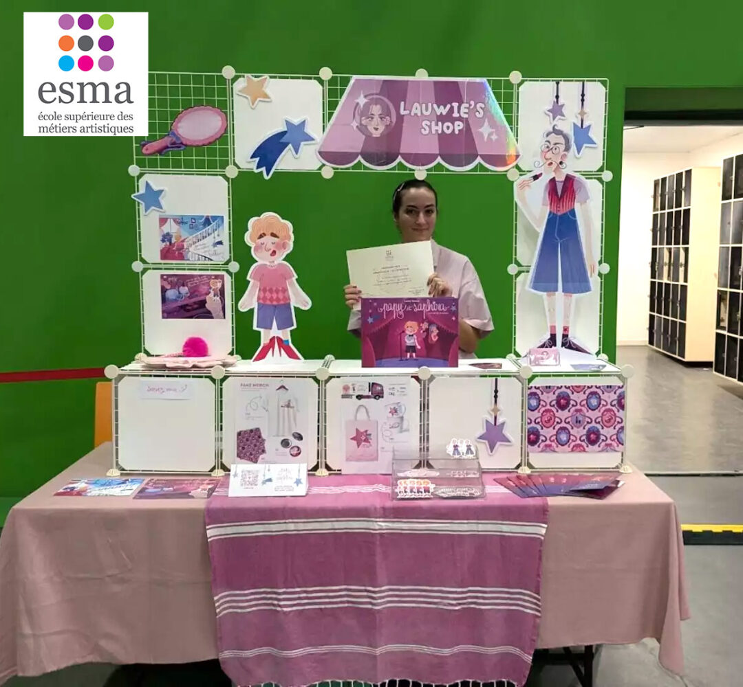 Student presenting Lauwie’s Shop, an ESMA Illustration Concept Art graduation project with character design and staged display materials.