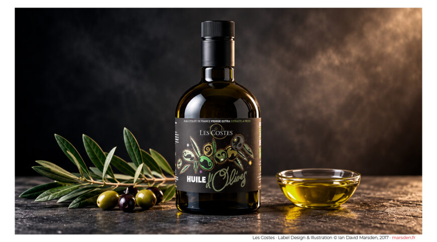 Dark glass olive oil bottle featuring original illustrated label design by Ian David Marsden, photographed with olive branches and a bowl of golden olive oil.